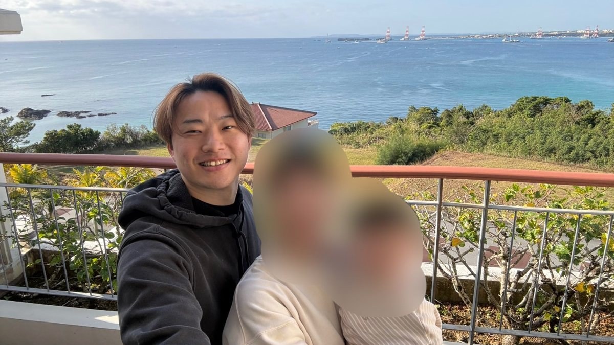 海を背にした、しらかわと妻と息子